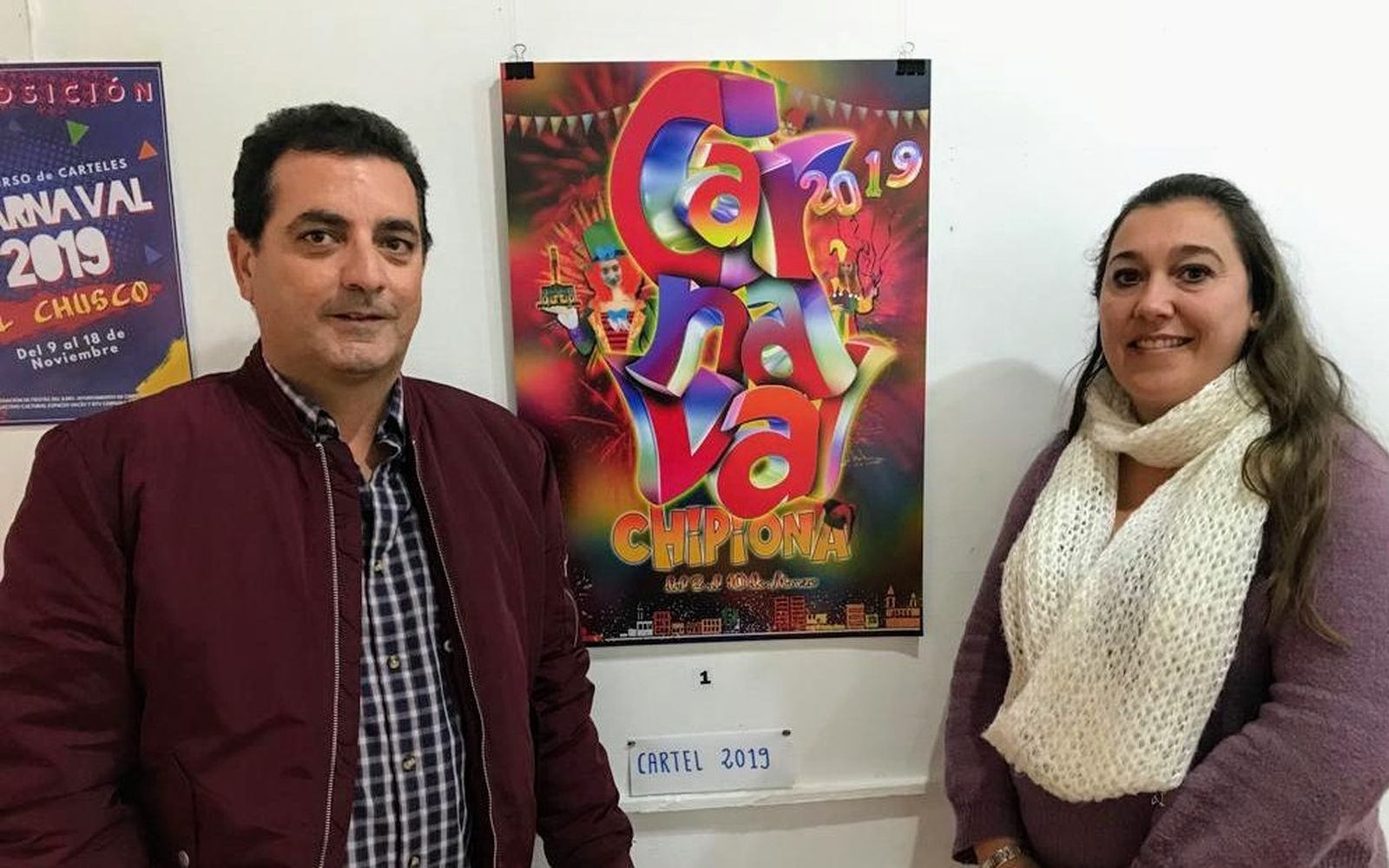 El autor mostrando el cartel elegido junto a la concejala de Fiestas, Davinia Valdés.