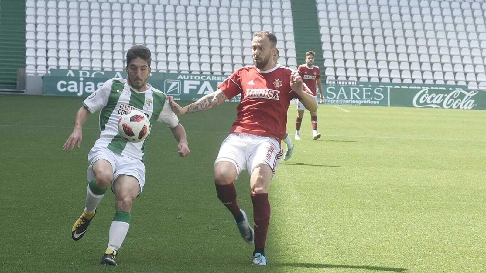 Un jugador blanquiverde intentar pasar el balón en presencia de Sergio Ortiz.