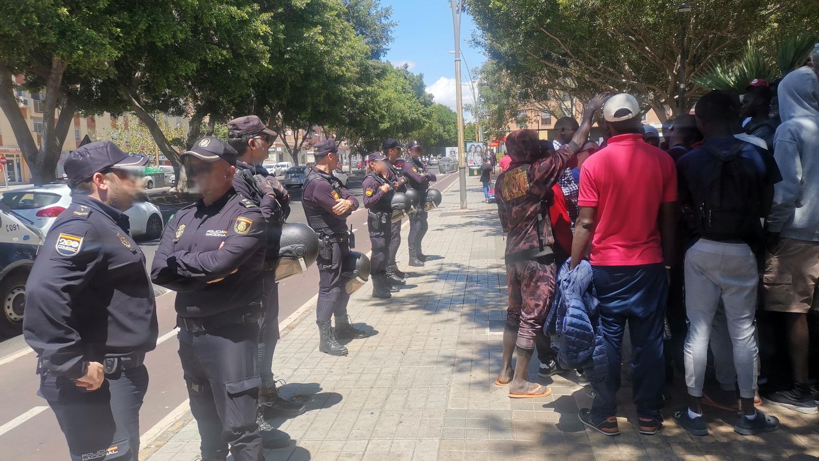 Agentes de Policía Nacional custodian a un grupo de inmigrantes de El Toyo en una protesta