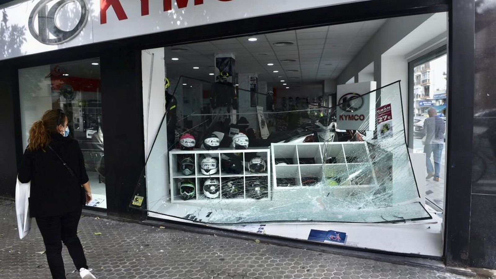 Estado en que quedó el escaparate de una tienda de motos de la Carretera de Carmona, tras sufrir un alunizaje.