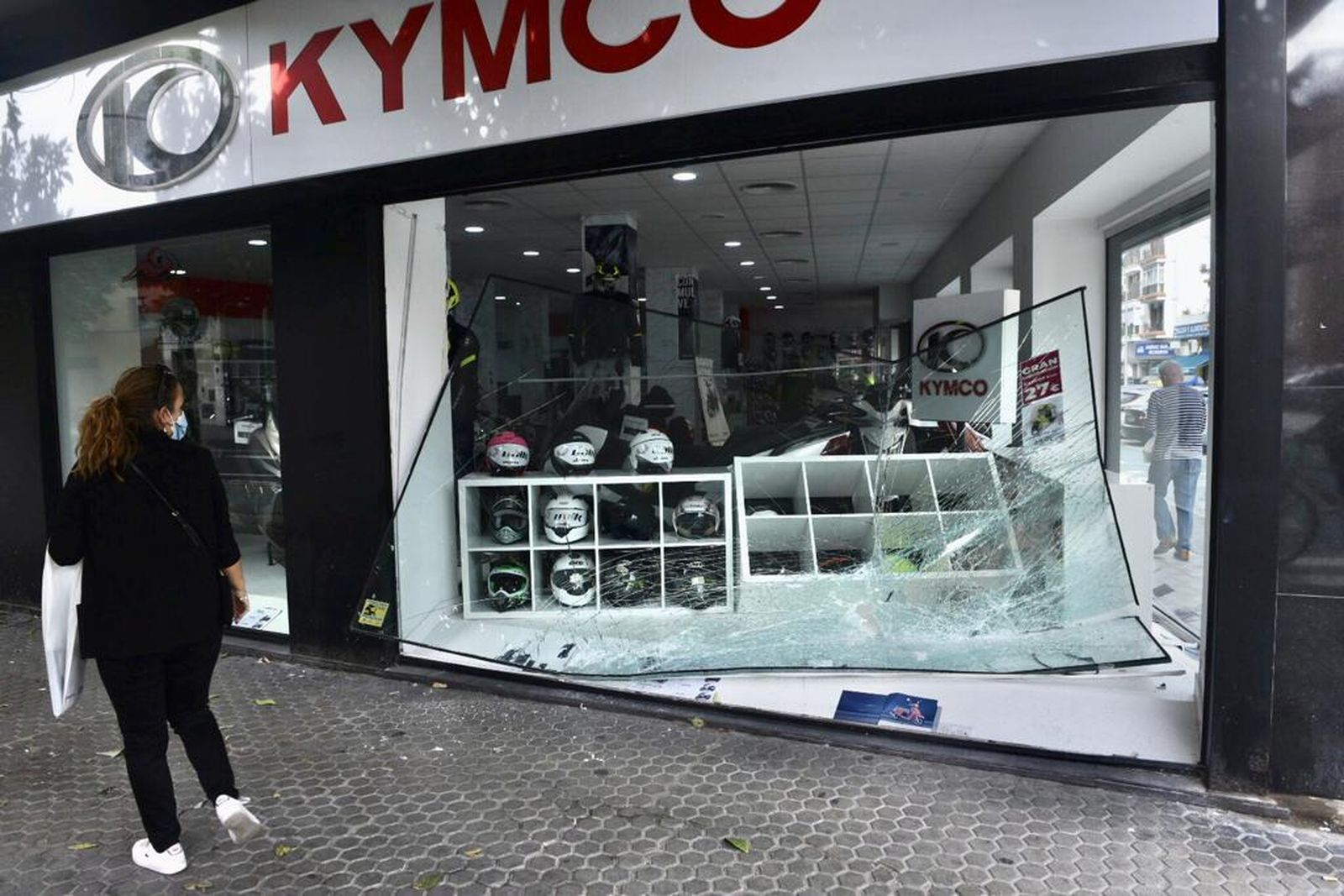 Estado en que quedó el escaparate de una tienda de motos de la Carretera de Carmona, tras sufrir un alunizaje.