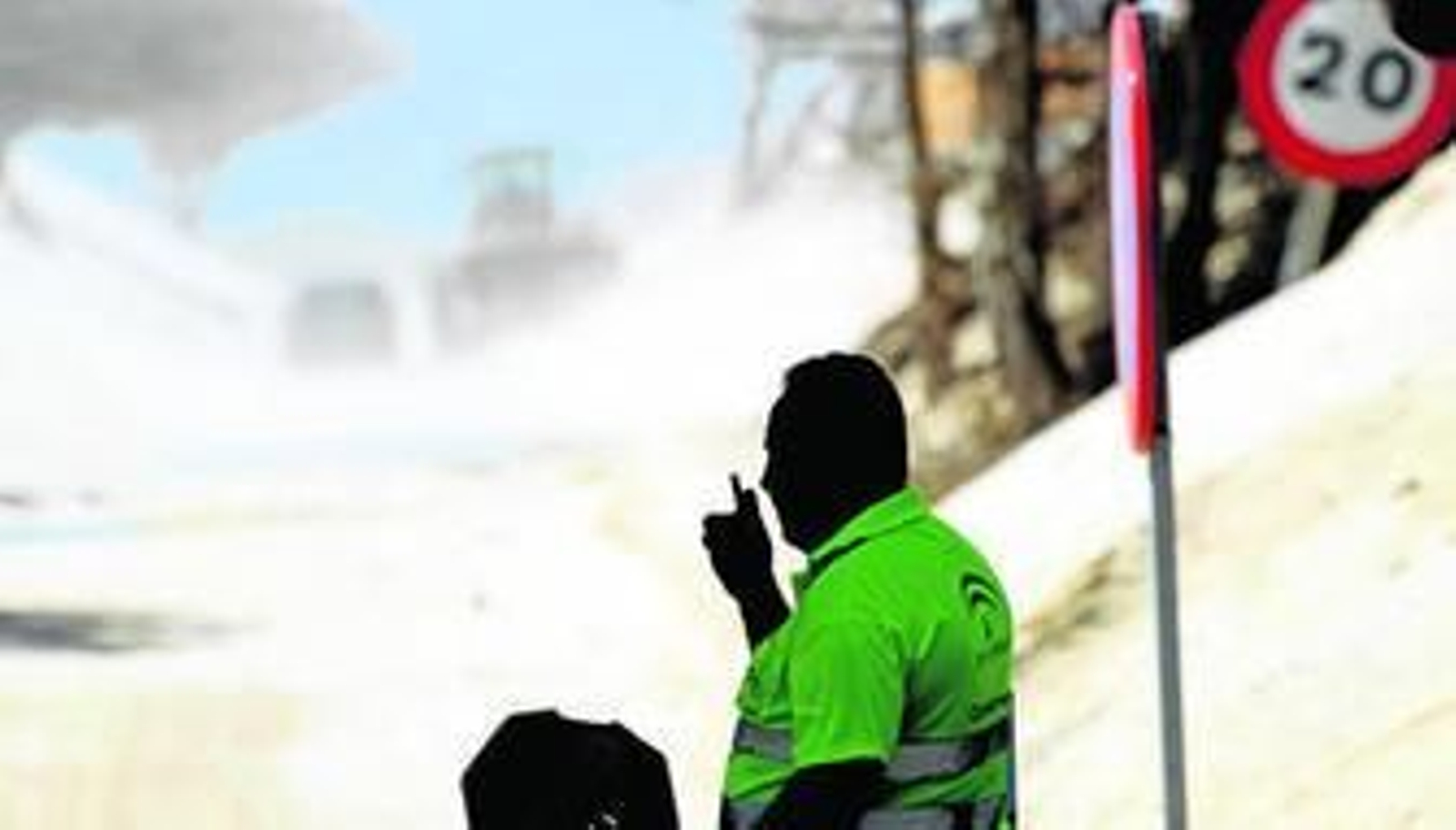Uno de los operarios regula el tráfico durante los trabajos de las excavadoras para retirar arena de uno de los taludes de la duna de Valdevaqueros.