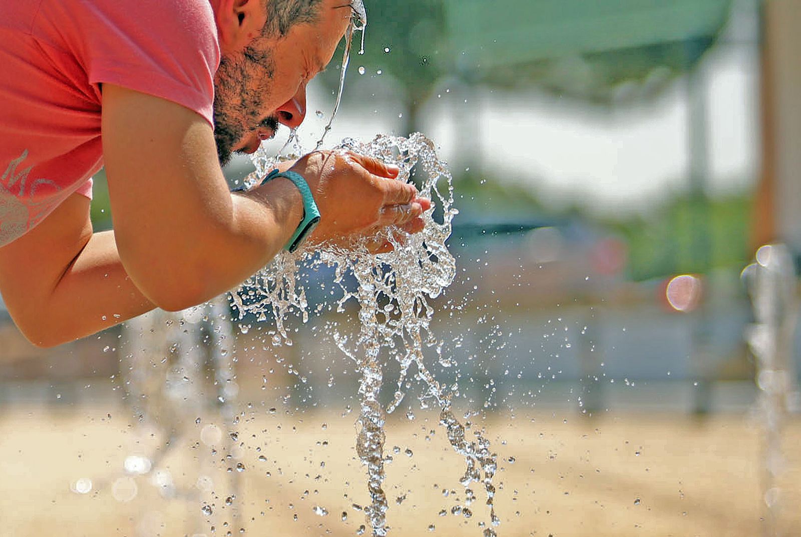 Un hombre se refresca por las altas temperaturas.