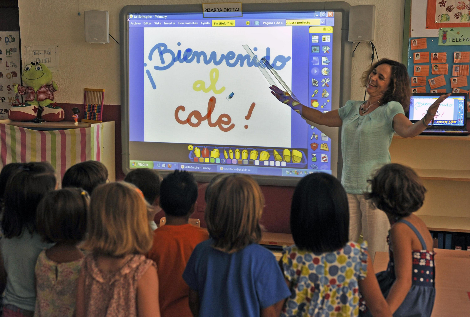 Una maestra da la bienvenida a los alumnos en el primer día de curso.