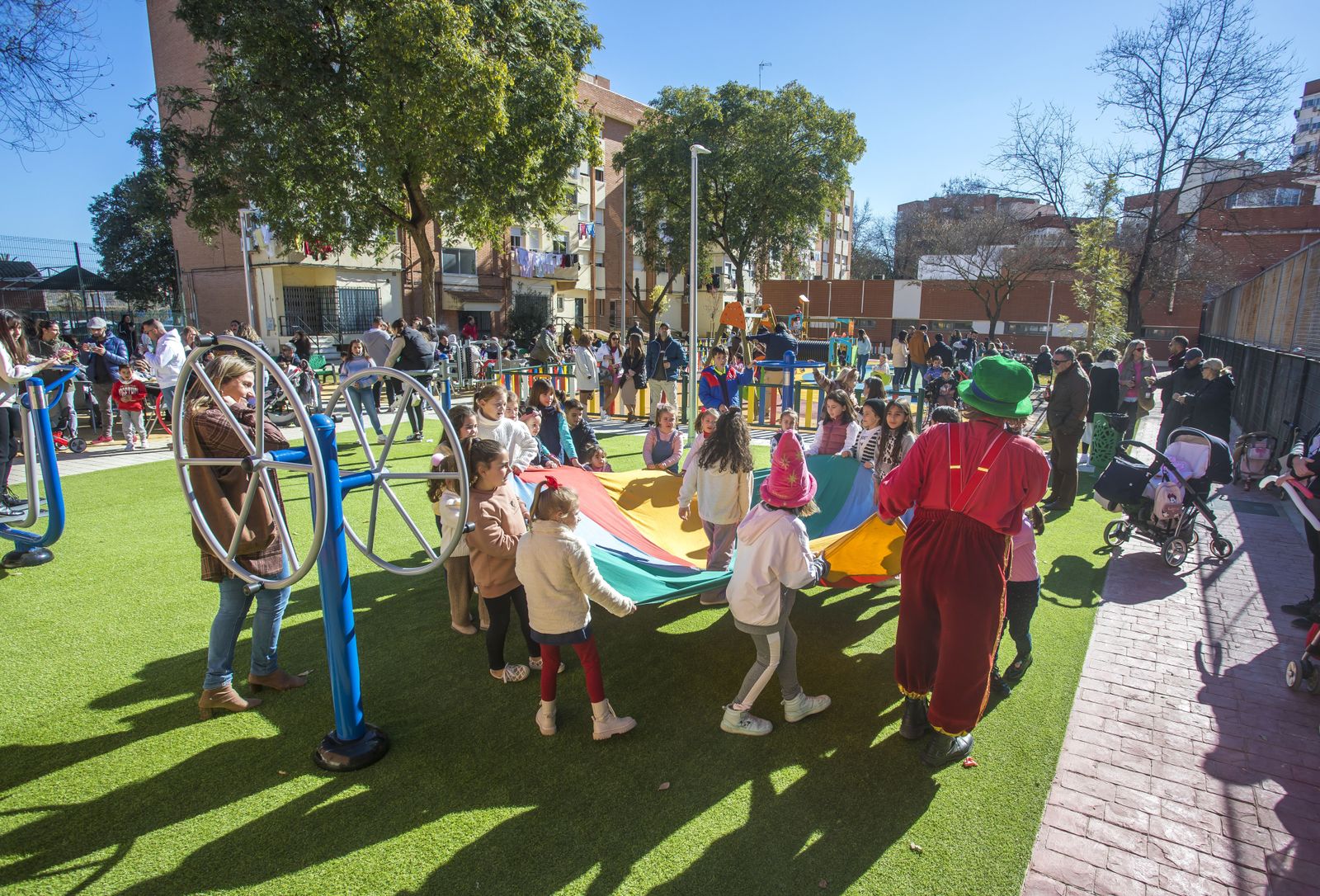 Niños y mayores en el nuevo parque infantil.