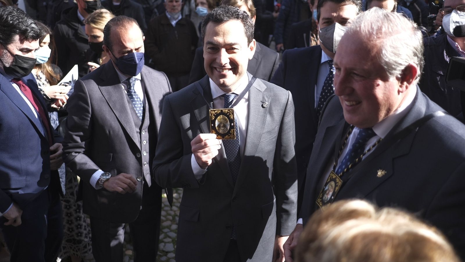 Juanma Moreno muestra un escapulario de la Virgen de los Dolores.