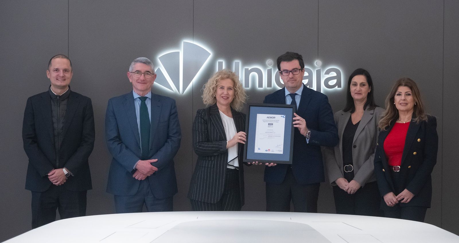 Representantes de institución al recibir el certificado.