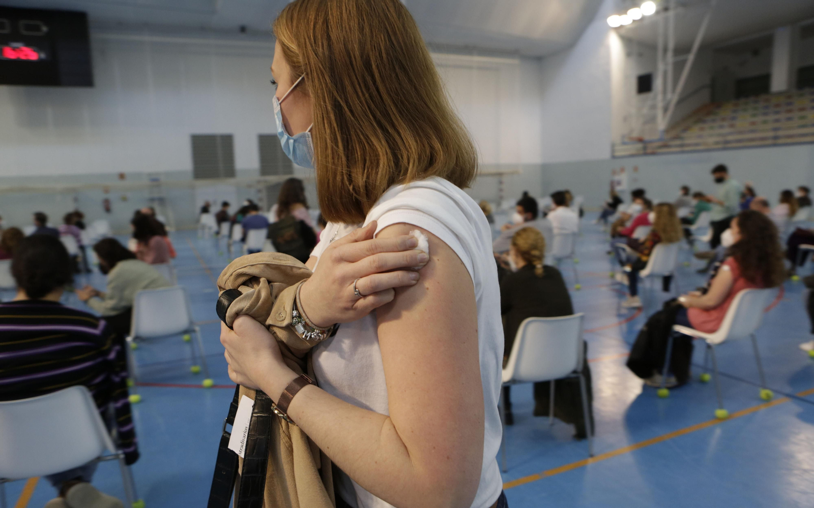Una profesora en Sevilla tras ser vacunada en el pabellón deportivo de Los Bermejales.