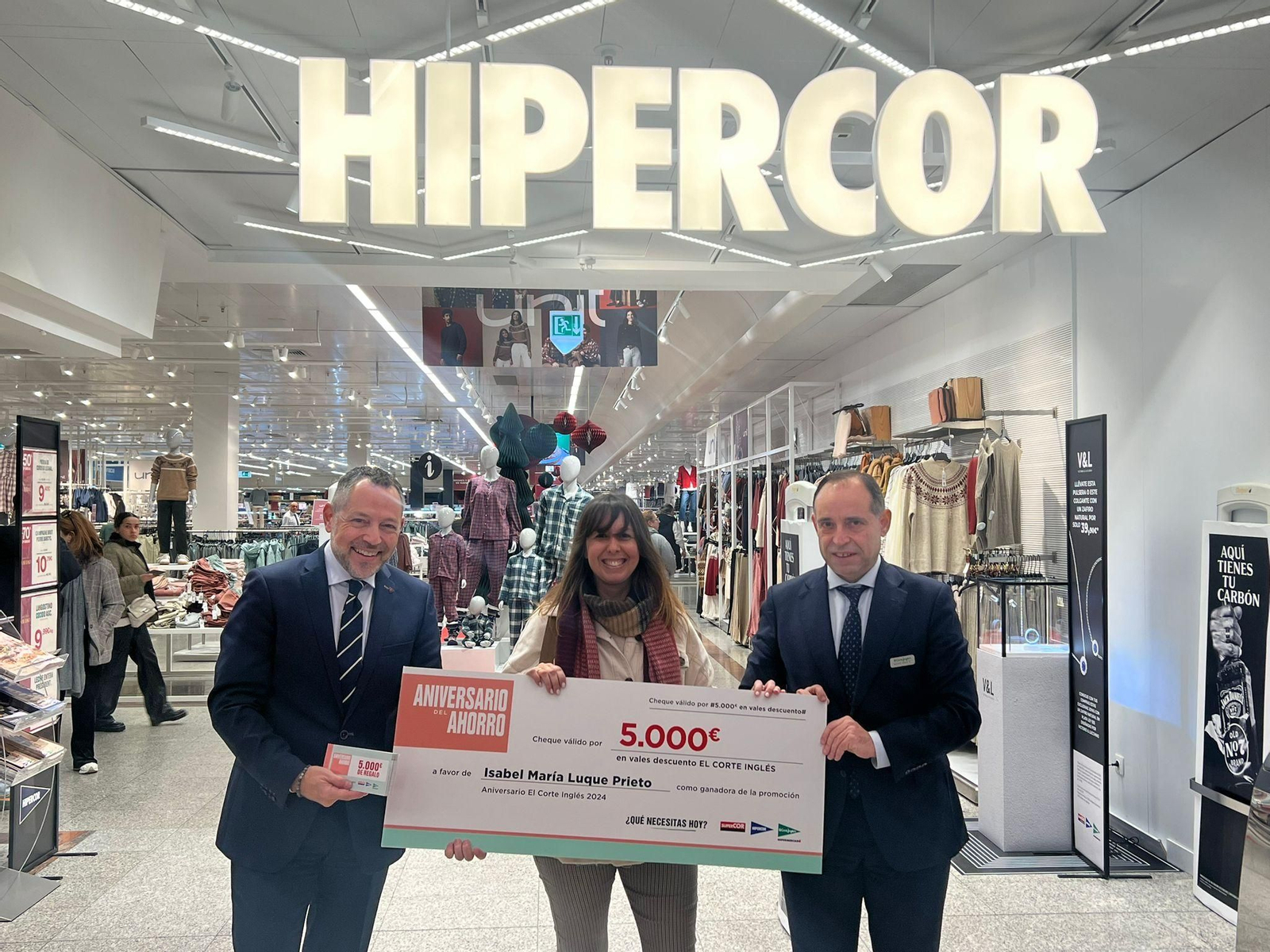 Ana María Luque Prieto recibe de manos del director de El Corte Inglés, Ramón Macías, y el responsable de Hipercor, Miguel Ángel Esteban, el talonario de 5.000 €.