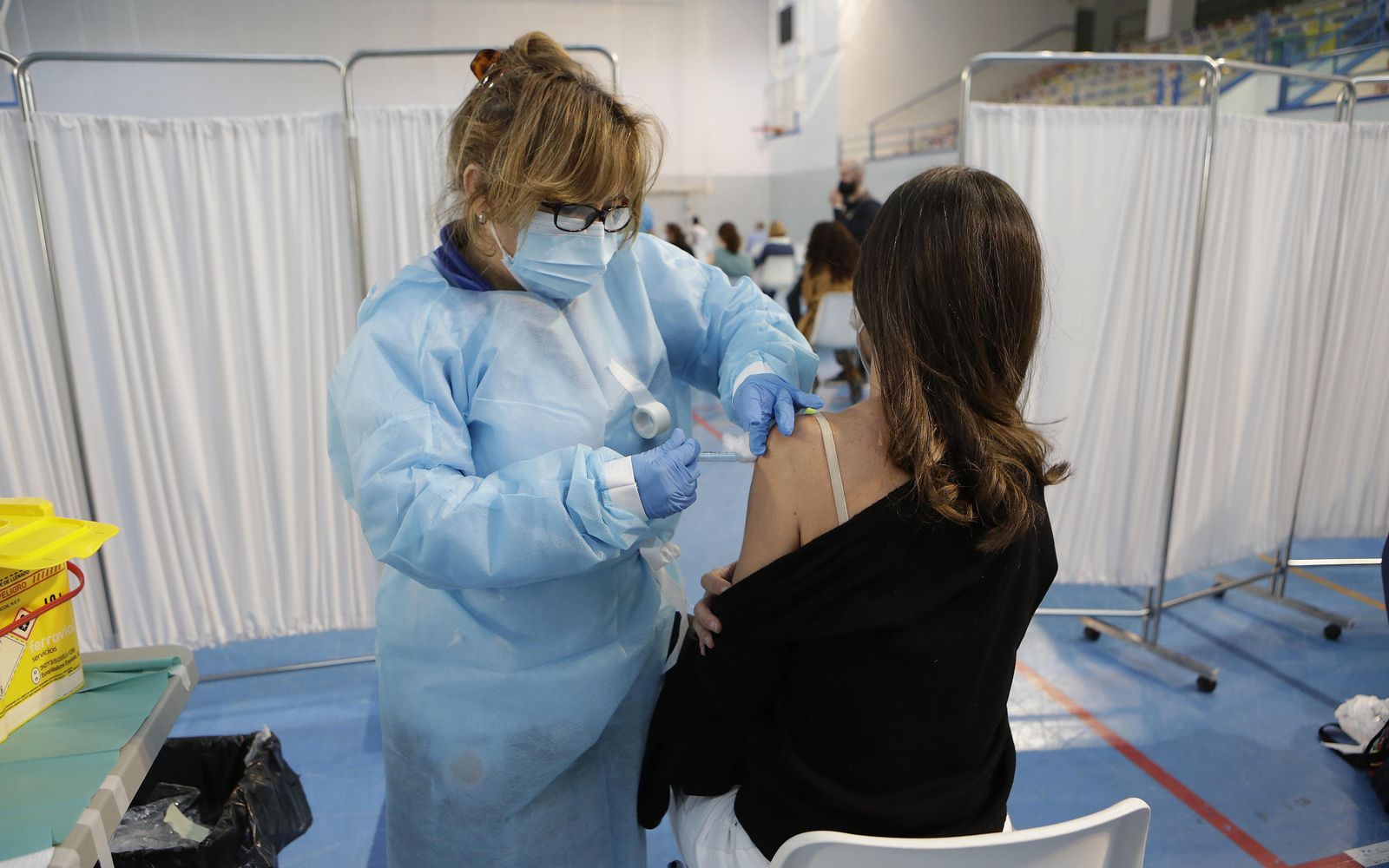 Una enfermera inyecta la vacuna contra la covid a una joven en Sevilla