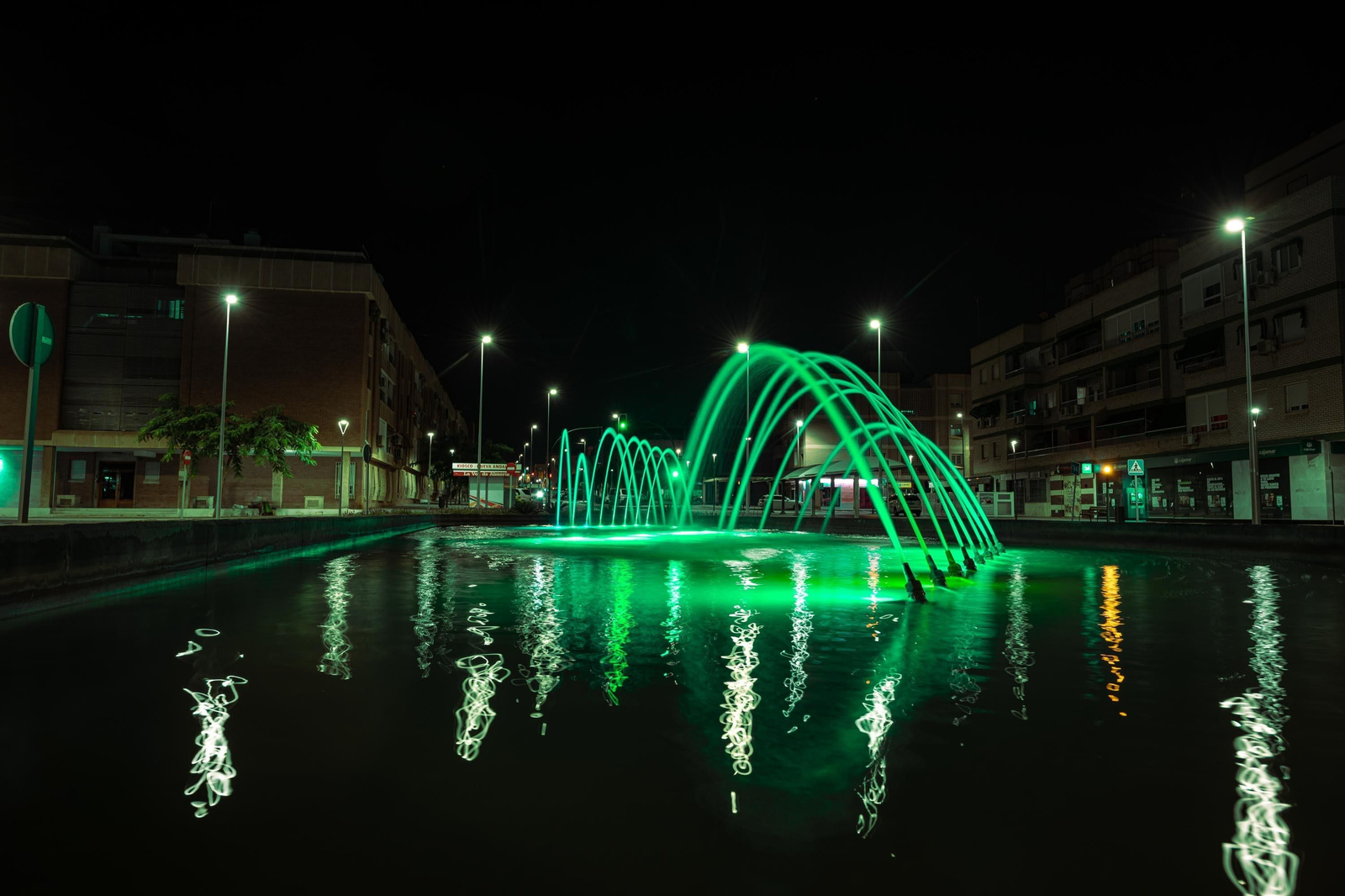 Una de las fuentes de la ciudad, iluminadas de color verde.