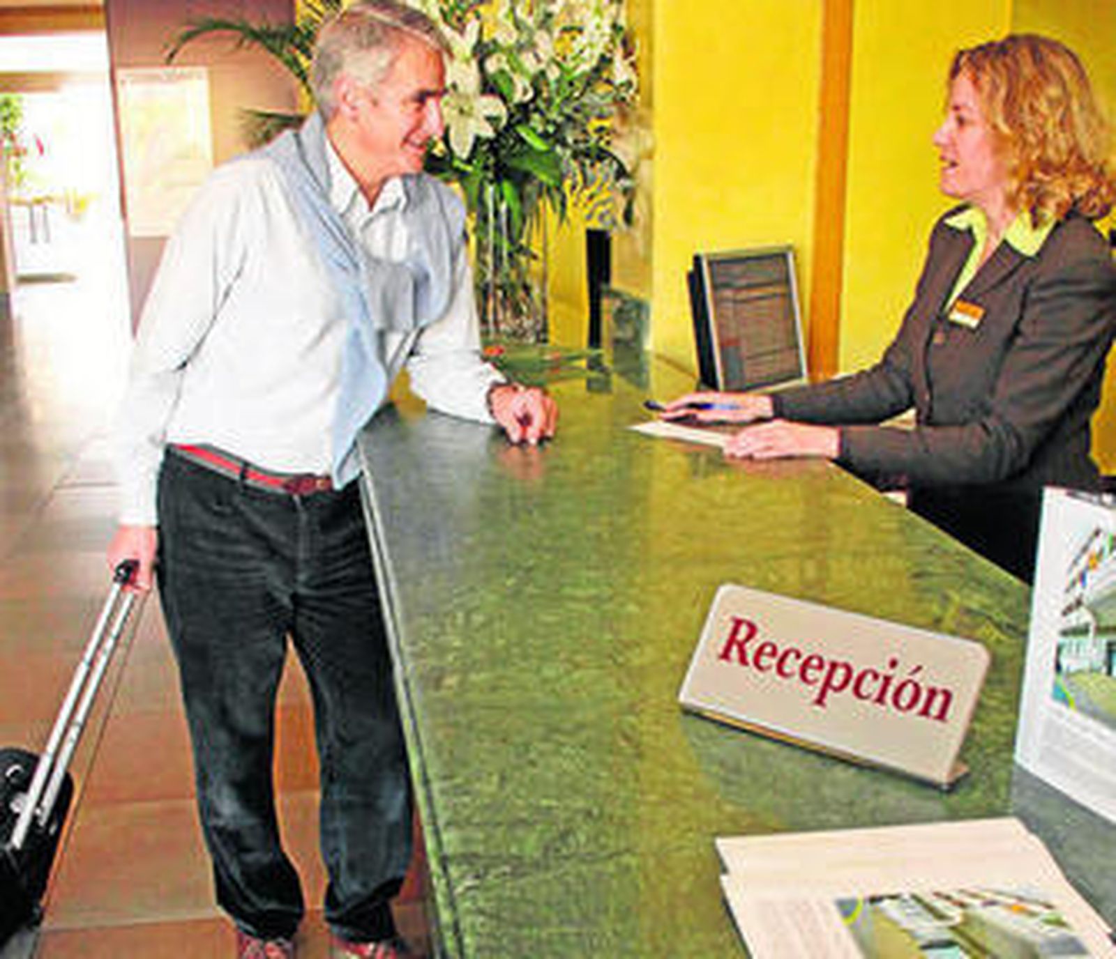 Un cliente en la recepción de un hotel, en una imagen de archivo.