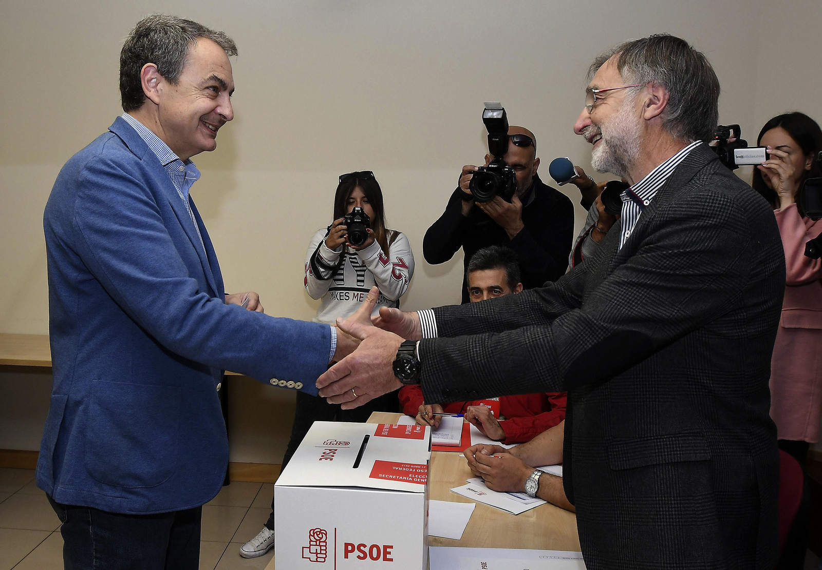 El ex presidente José Luis Rodríguez Zapatero saluda al presidente de la mesa electoral antes de votar.