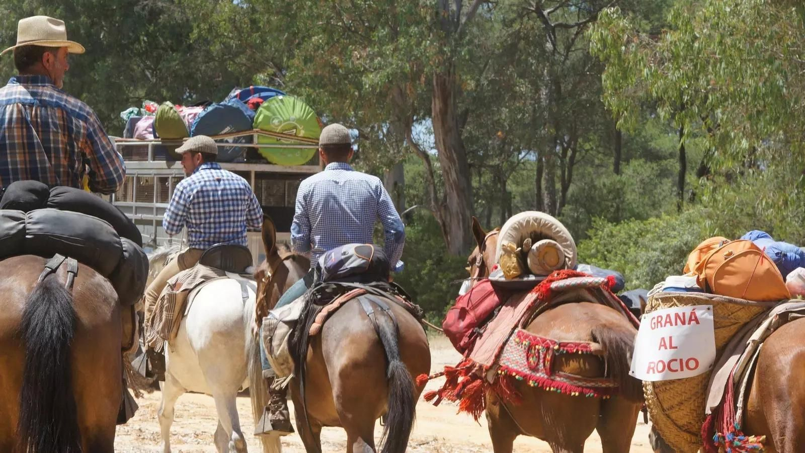 Varias personas montando a caballo en El Rocío.