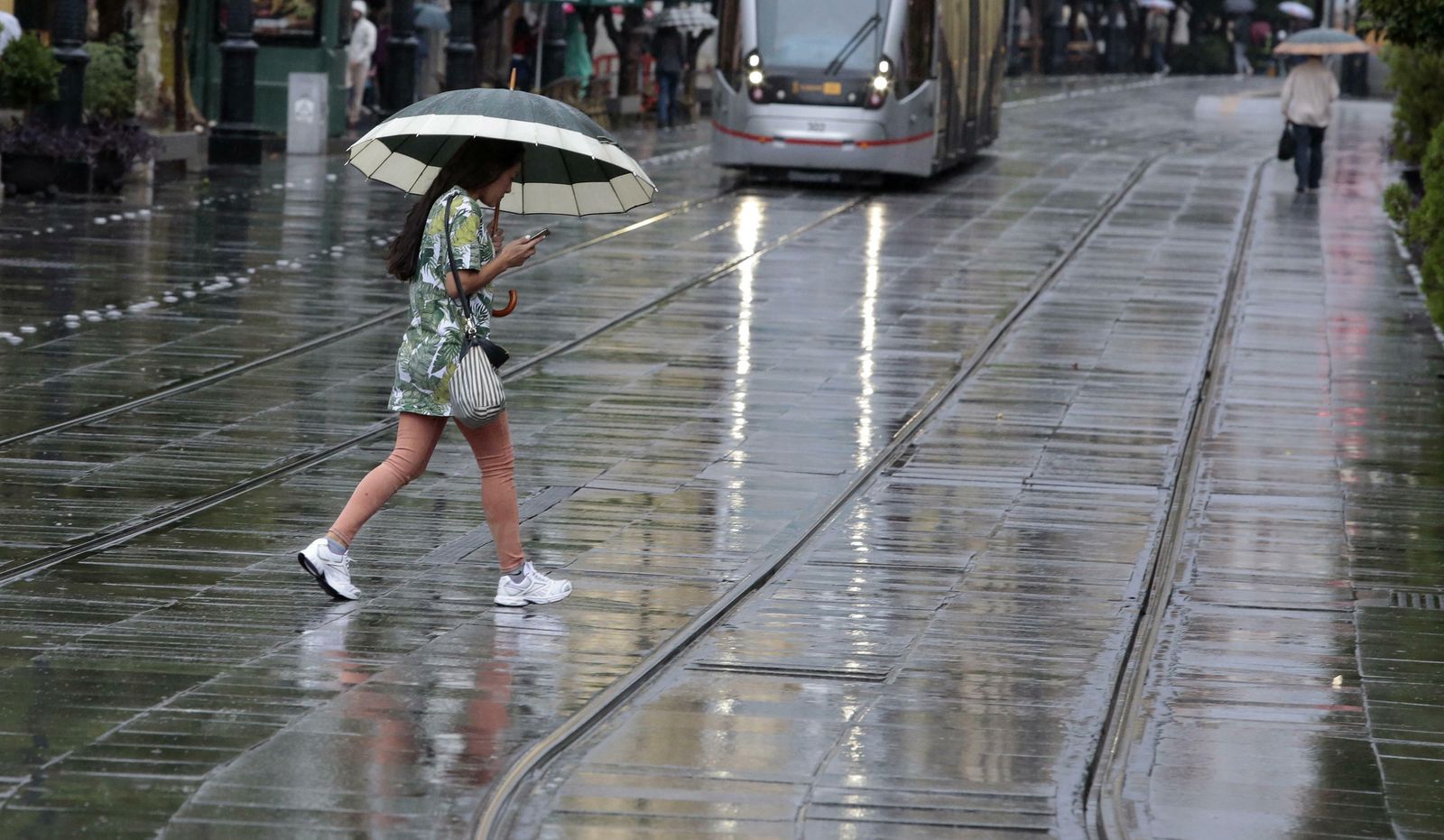Mujer con paraguas caminando por el centro de la ciudad