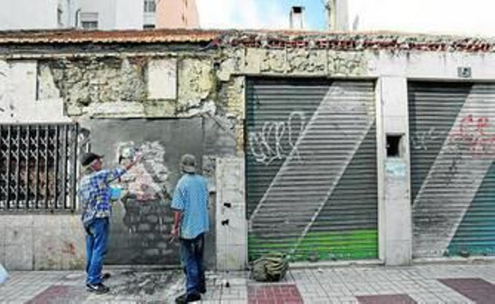 Dos personas señalan el local en el que vivía Reinert y que ha sido tapiado por el Ayuntamiento. Dos personas señalan el local en el que vivía Reinert y que ha sido tapiado por el Ayuntamiento.