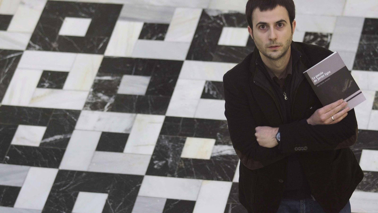 Jairo García Jaramillo posa con el libro 'La poesía de Javier Egea', una revisión del estudio sobre la obra del poeta publicado en 2005.