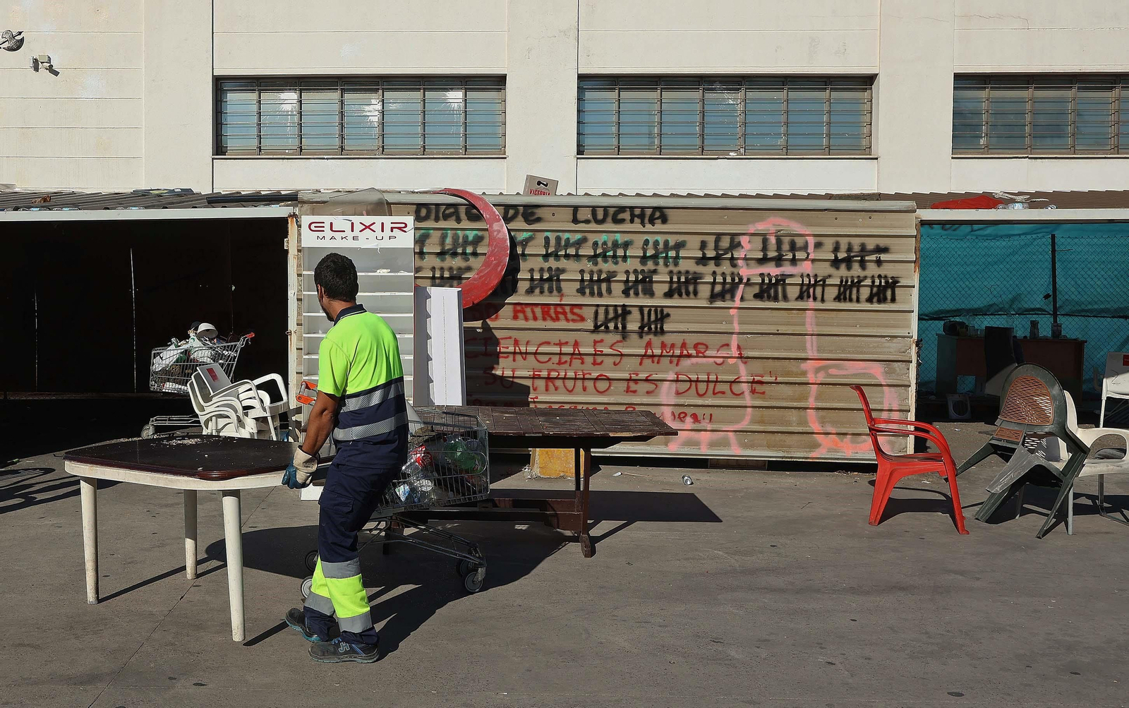 Una persona retira mesas y enseres de los aparcamientos de Acerinox.