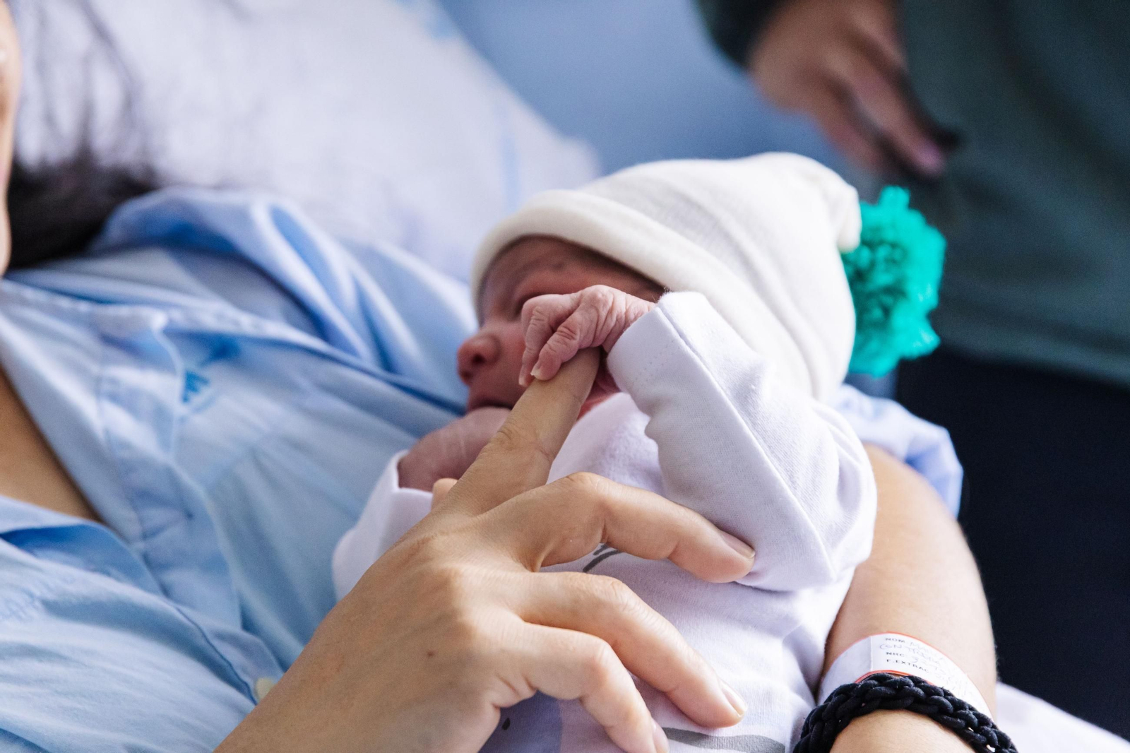 Un recién nacido se agarra a su madre. Un recién nacido se agarra a su madre.