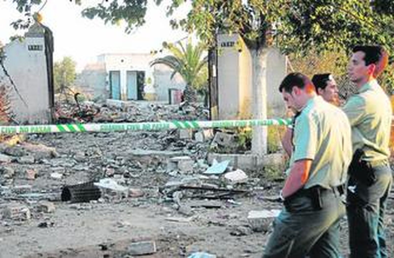 Dos agentes de la Guardia Civil observan los restos de la pirotecnia Nuestra Señora de las Nieves.