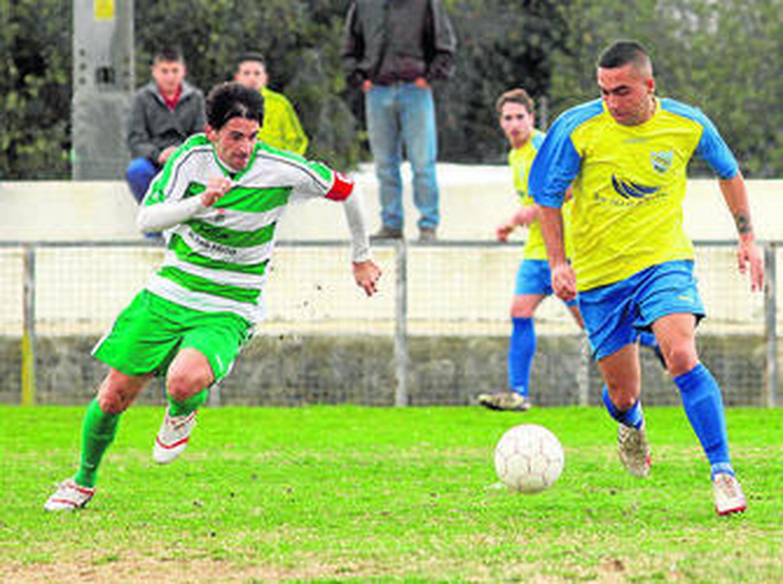 Javi Muñoz (i) persigue el balón en pugna con un adversario.
