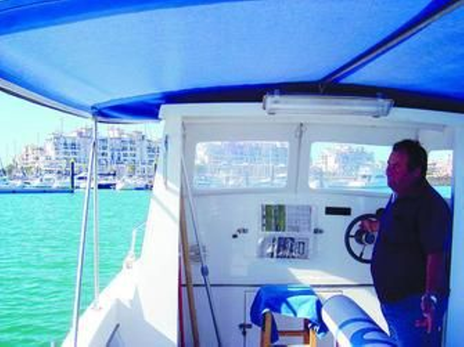 1. Agustín Martín, marinero que está al frente del barco-taxi entre Isla Cristina y Punta del Moral, ayuda a una turista a entrar en su embarcación. 2 y 3. Agustín Macías, al frente del timón del barco. 4. Varios turistas disfrutan del paseo entre la población ayamontina y la isleña.