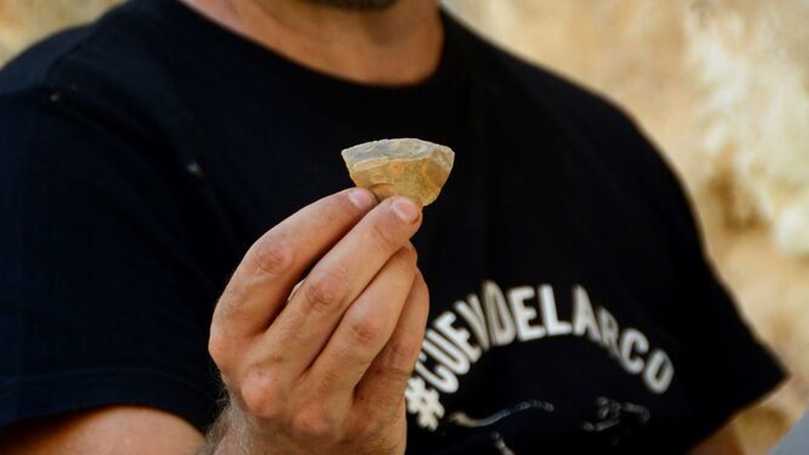 Uno de los investigadores muestra un trozo de hueso