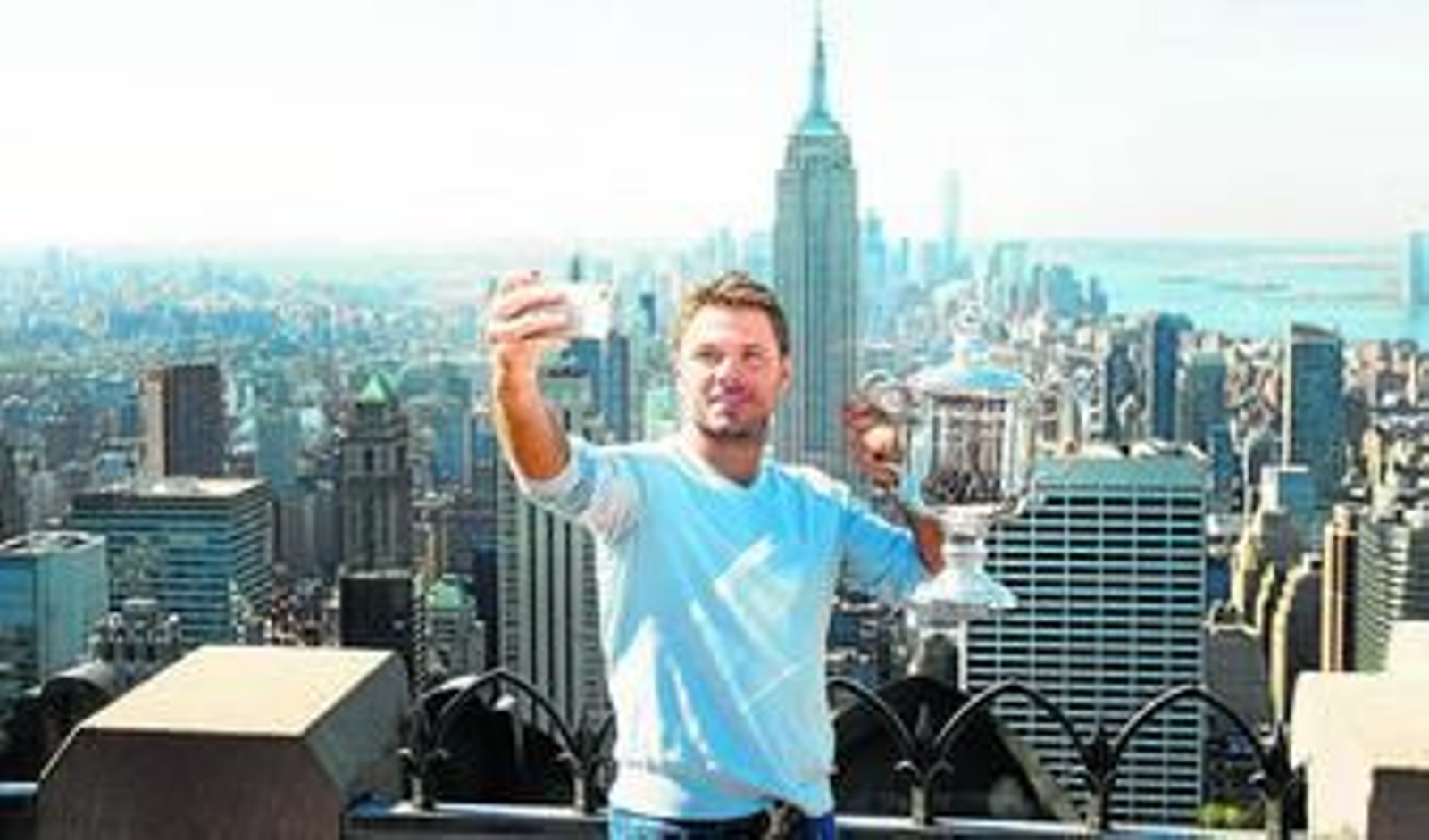 El tenista suizo Stanislas Wawrinka posa junto a su trofeo de campeón durante un evento en Nueva York.