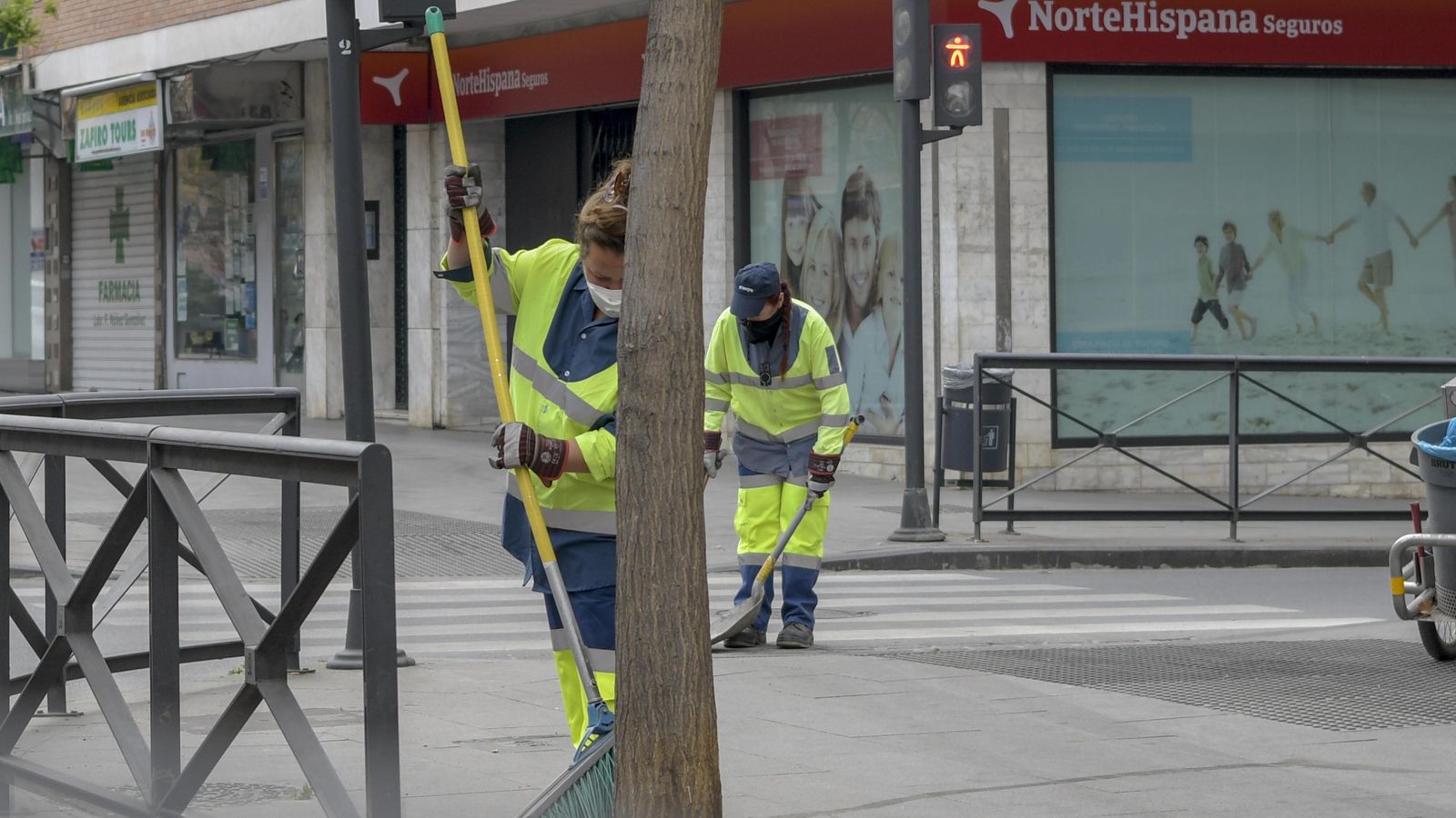 Dos barrenderas, protegidas, trabajando ayer en Granada.