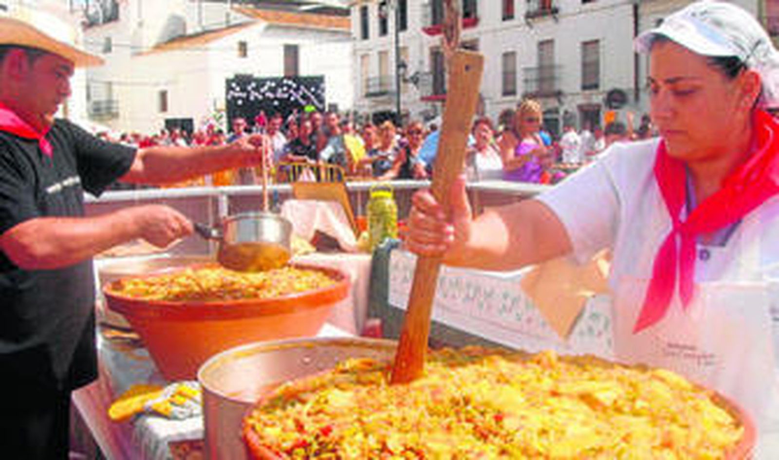 Dos vecinos de la localidad preparan sopas perotas para los visitantes.