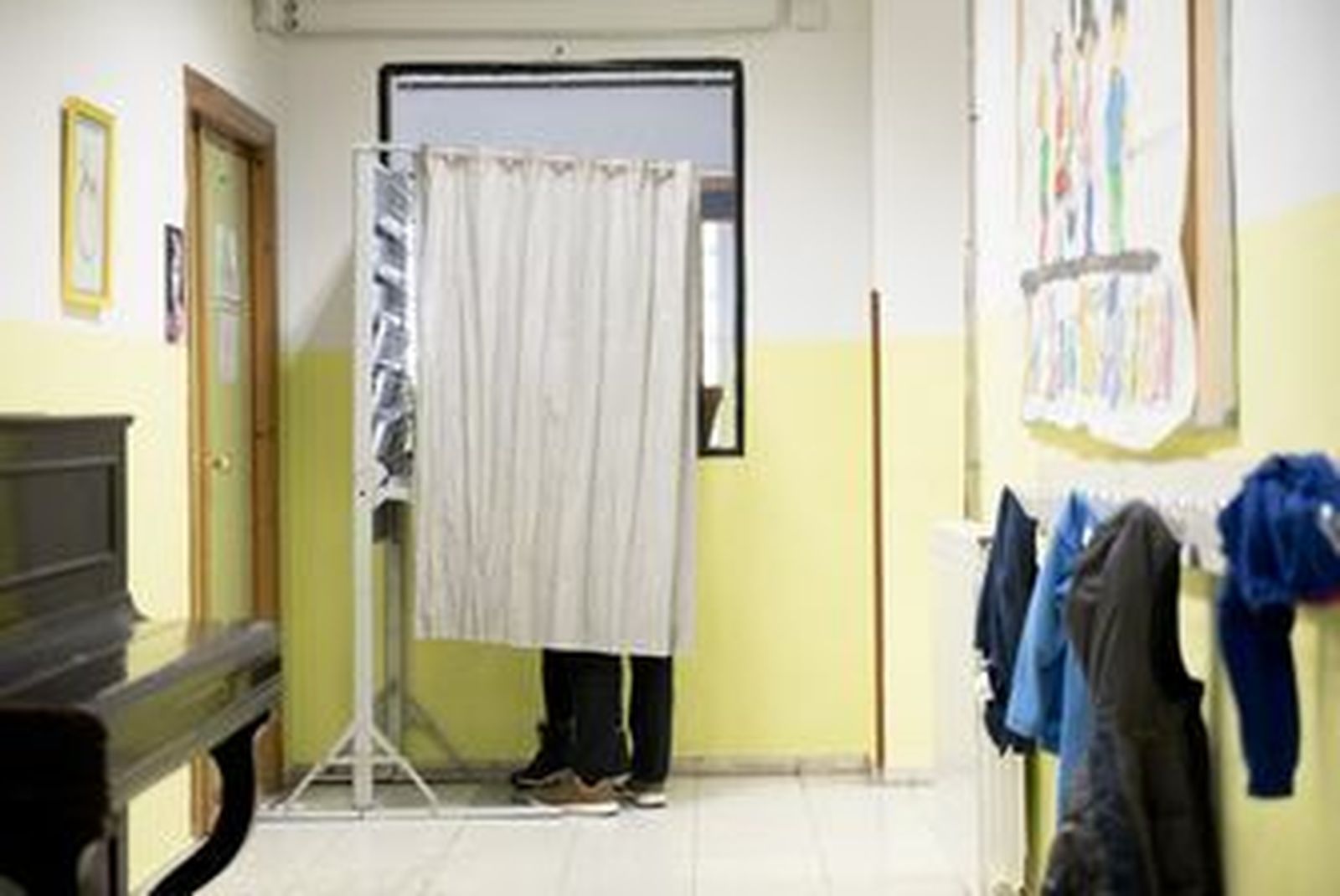 Una persona utiliza una de las cabinas dispuestas en un colegio electoral antes de votar.