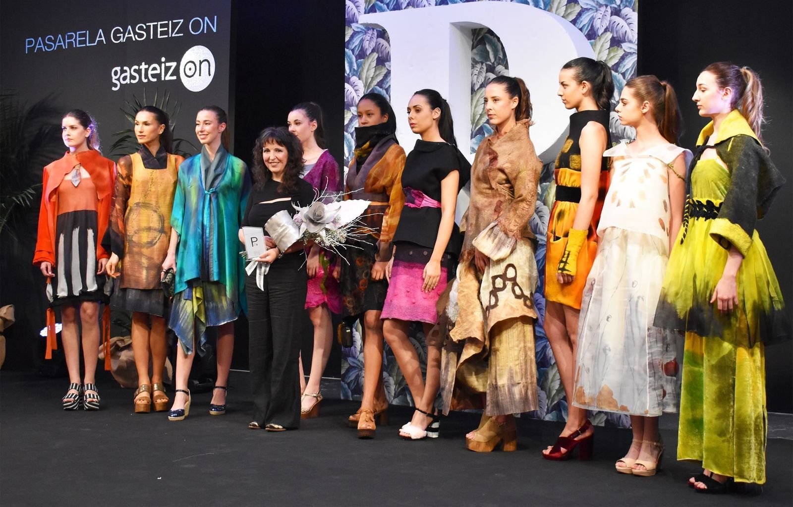 La diseñadora granadina posando con las modelos que lucen sus diseños tras un desfile de moda.