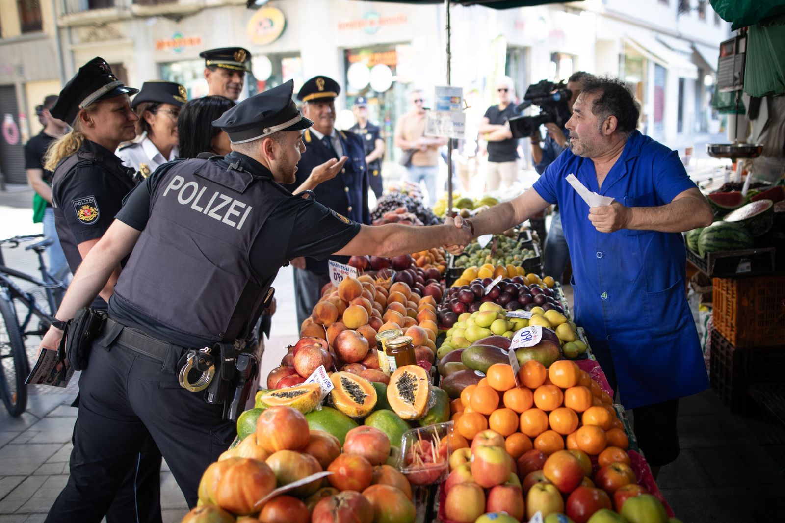 Dos agentes de la policía italiana saludan a un comerciante de Granada.