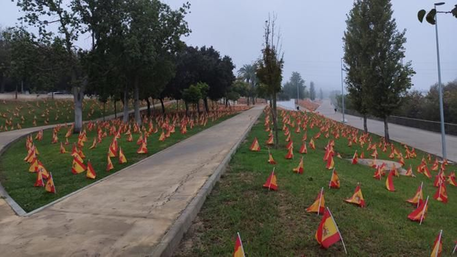 Ladera del río Guadalquivir con banderas de España en "homenaje" y para "pedir justicia" por los fallecidos del Covid.