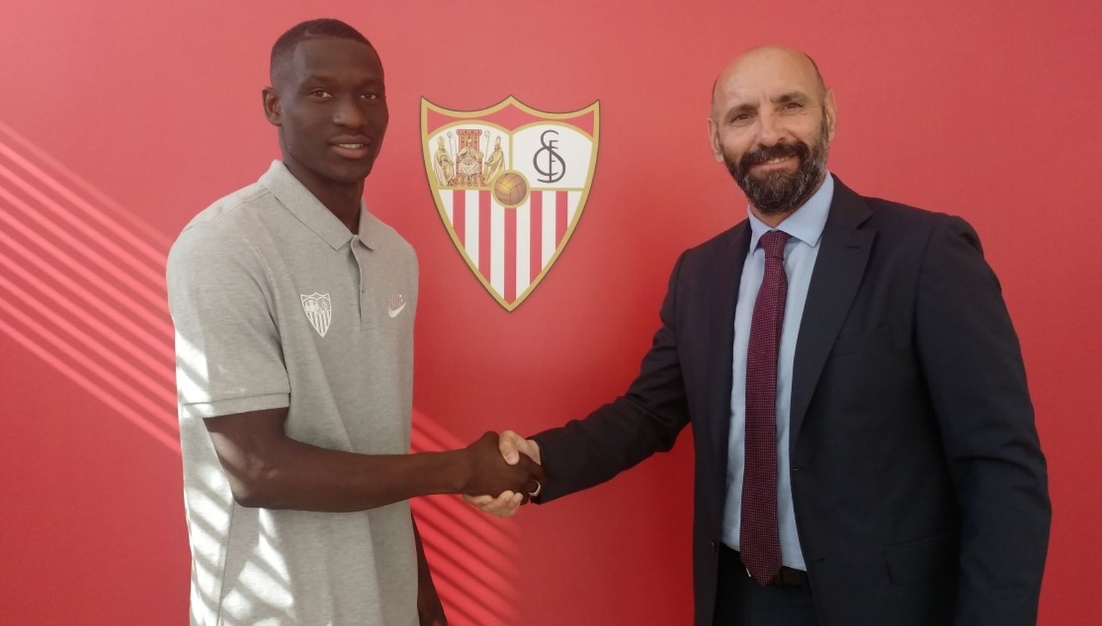 Diabate estrecha la mano de Monchi tras su fichaje.