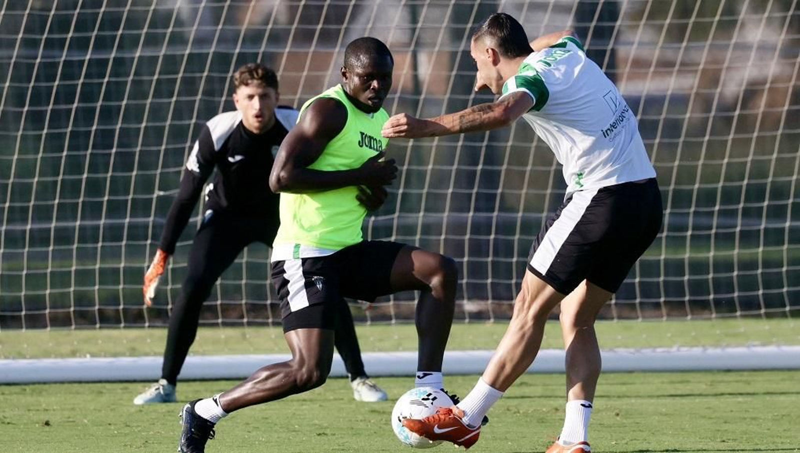 Sergi Guardiola golpea el balón en presencia de Fomeyem y Carlos Marín.