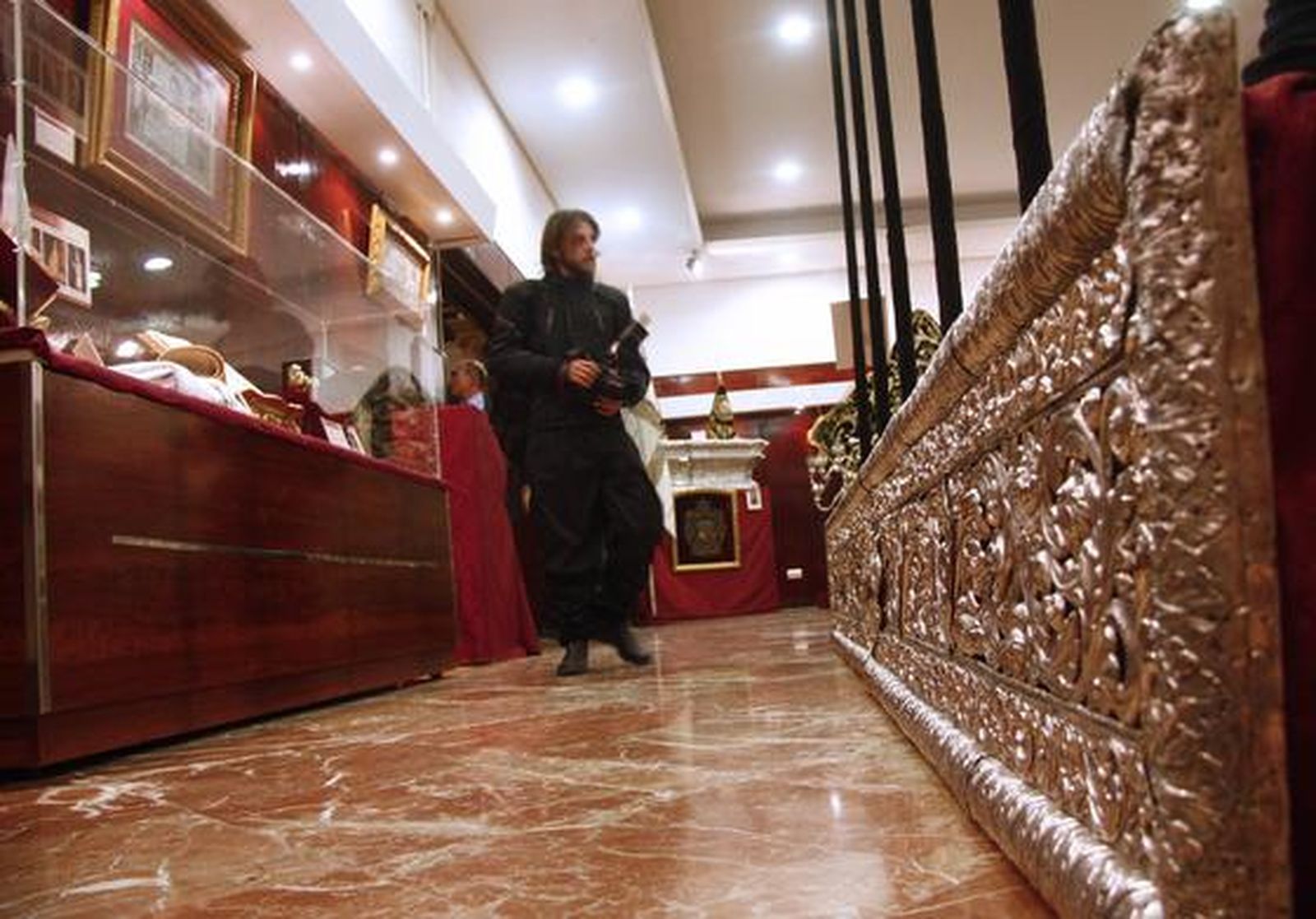 Los visitantes aprecian los objetos de la exposición "Tan lejos y tan cerca", de la Hermandad de la Amargura.

Foto: Belen Vargas