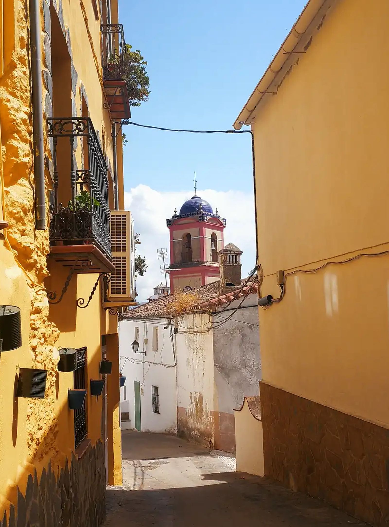 Una de las calles de Algatocín con la Iglesia de Nuestra Señora del Rosario al fondo.