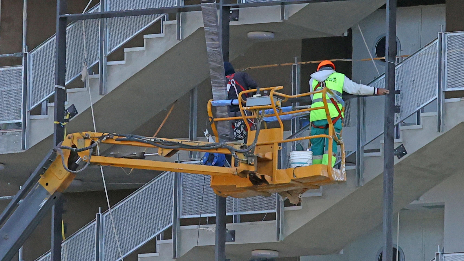 Un trabajador de la construcción subido en un andamio.