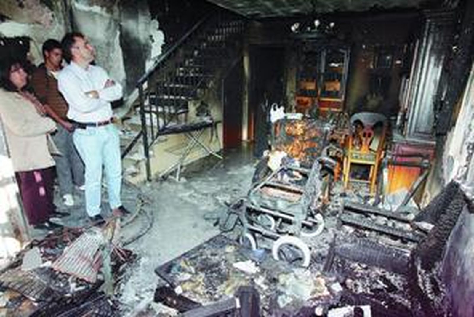 Familiares de la víctima observan desolados el estado de la vivienda.