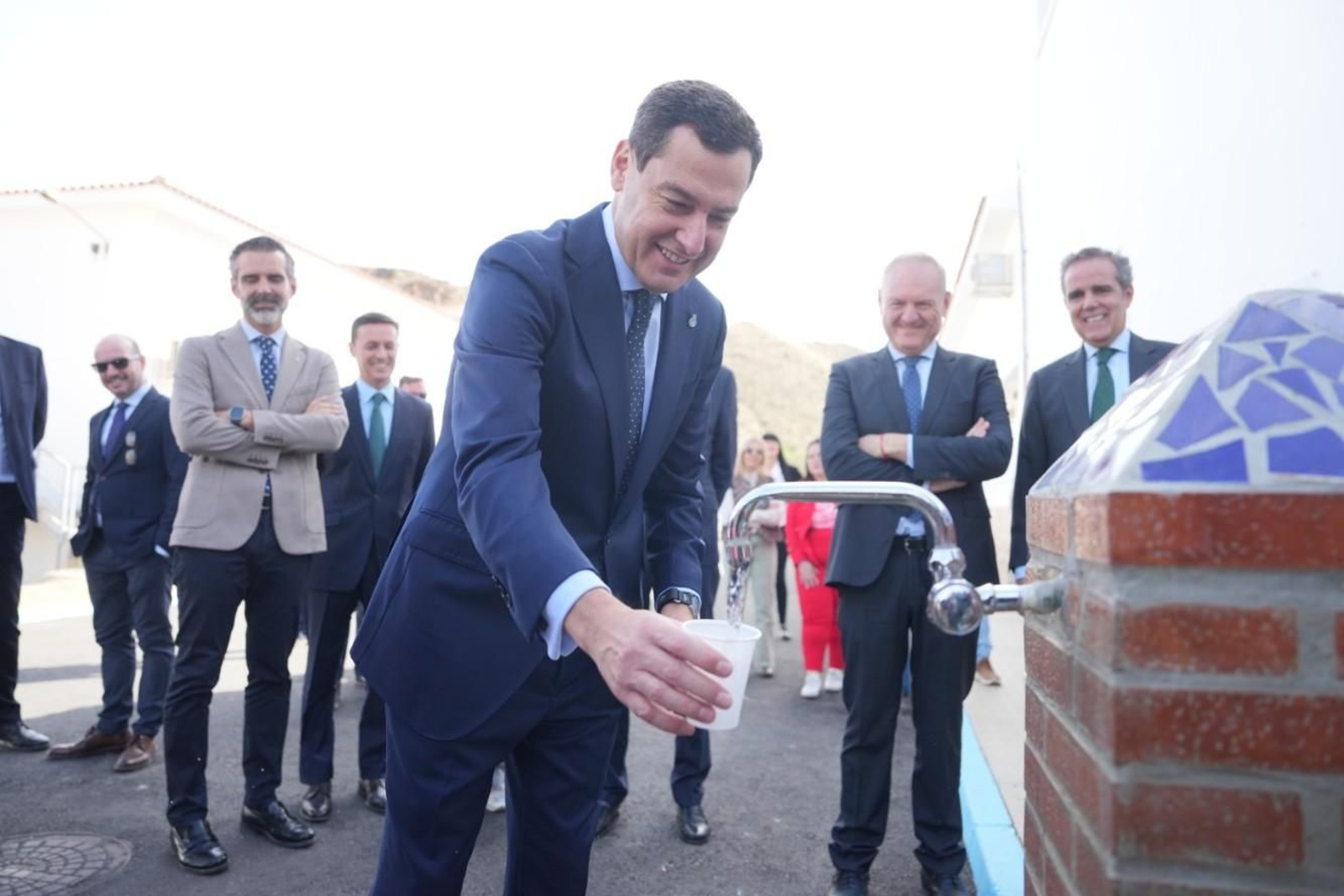 El presidente de la Junta llena un vaso de agua de la potabilizadora.