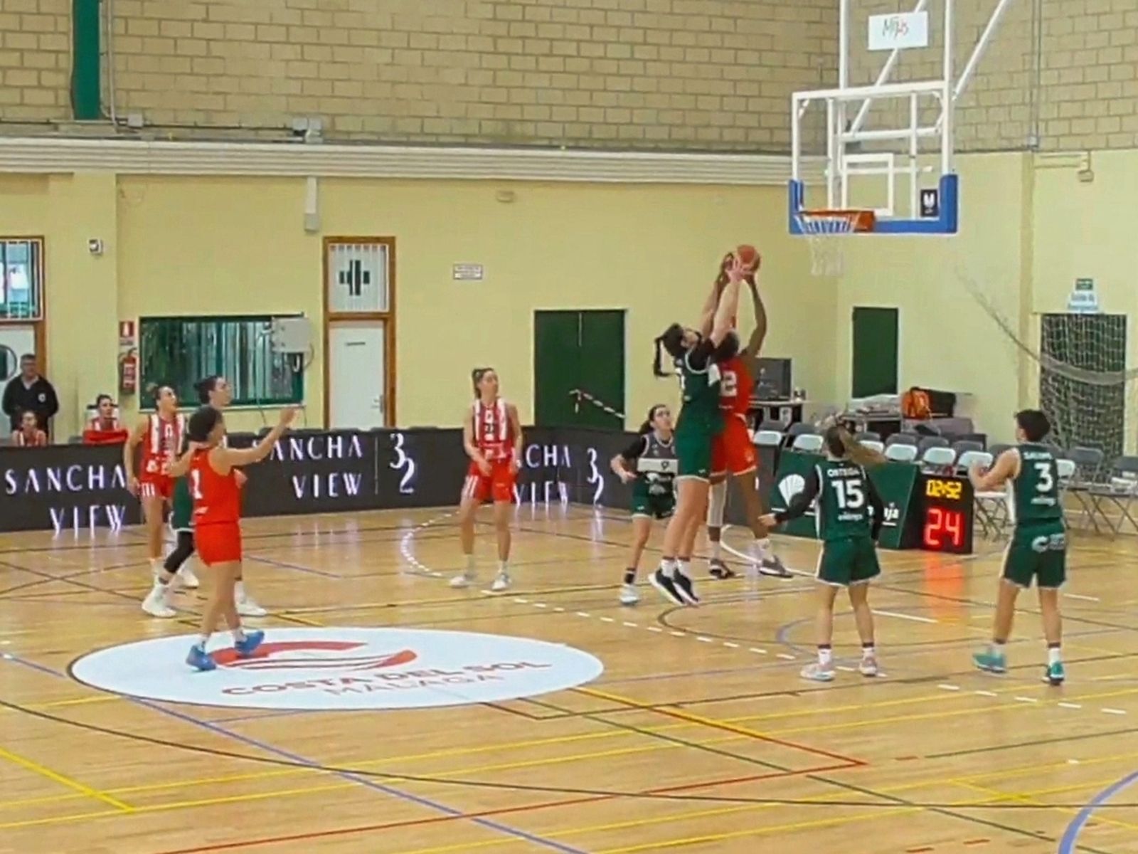 Una jugadora de Unicaja intenta taponar tiro del conjunto rojillo.