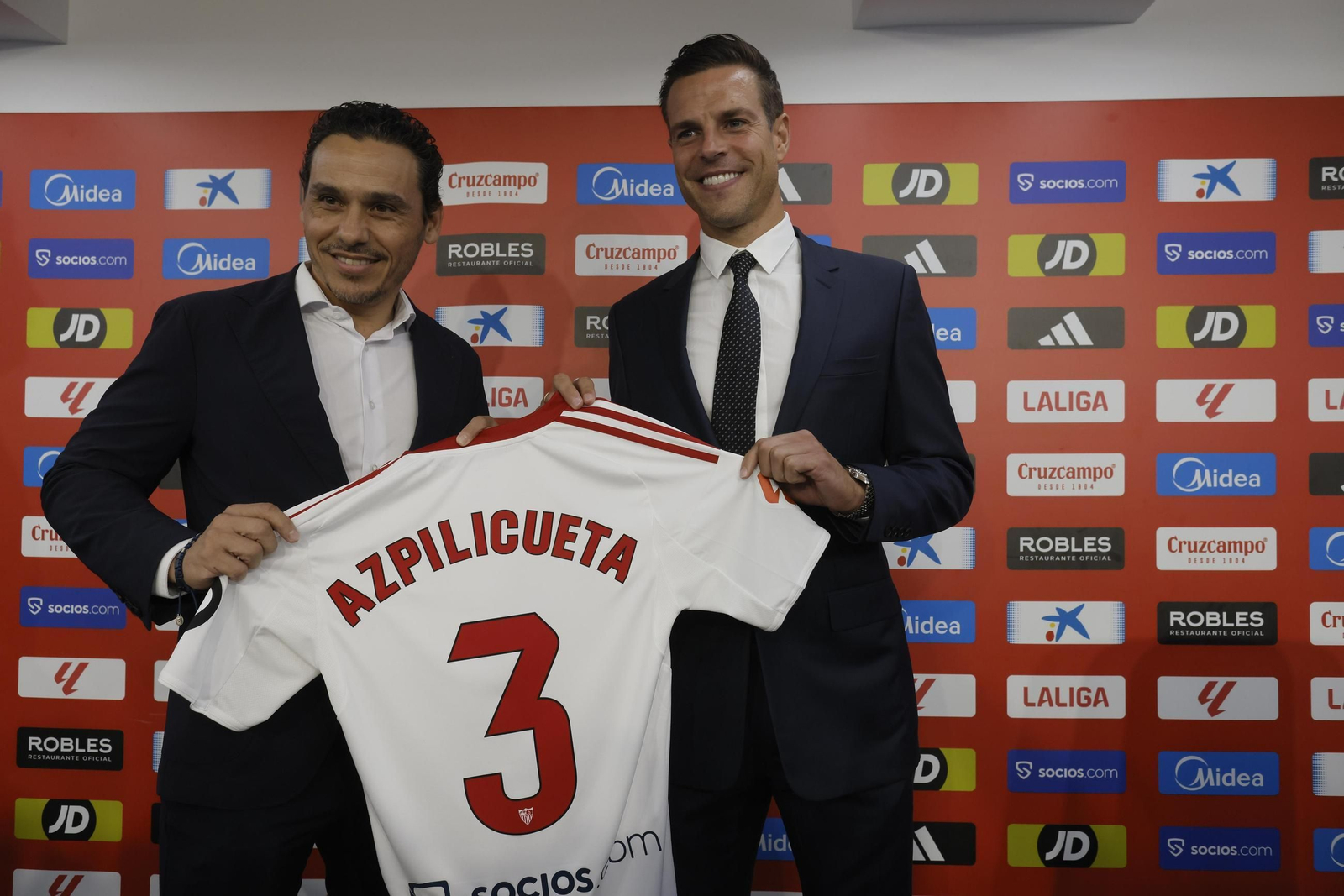 César Azpilicueta sonríe mientras muestra su camiseta con el 3 junto a José María del Nido Carrasco.