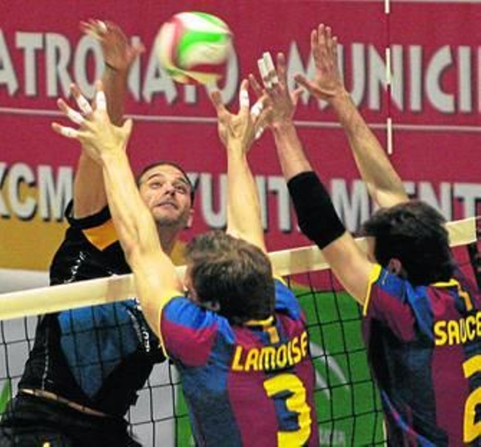 El jugador del Cajasol Juvasa Yustiz remata ante el bloqueo formado por Lamoise y Saucedo.