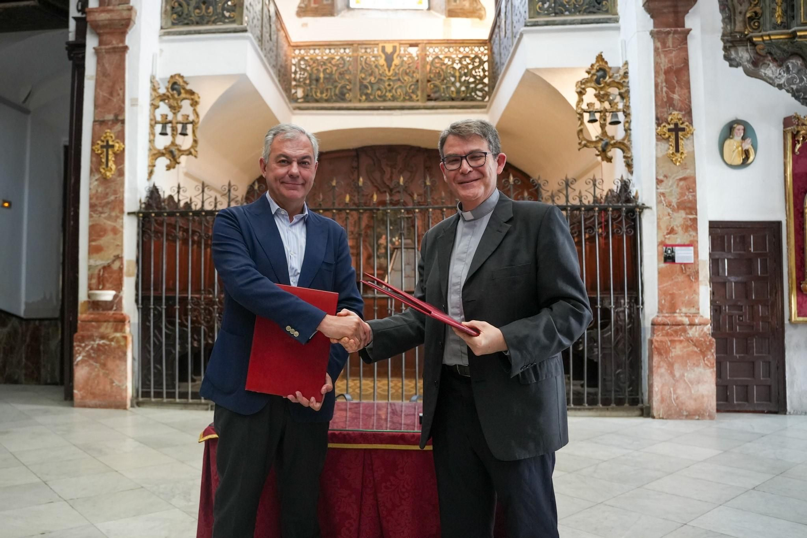 El alcalde de Sevilla, José Luis Sanz, y el párroco, Miguel Ángel Núñez Aguilera, tras firmar el convenio de colaboración para una ayuda de 212.229 euros.