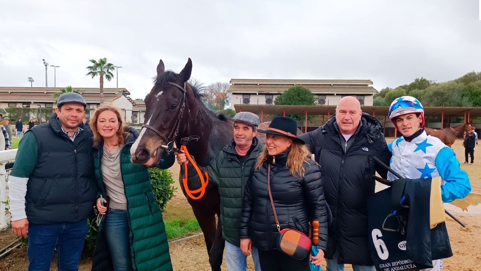 El jockey José Gómez, con el purasangre Sanat y sus propietarios tras ganar la tercera carrera de la jornada.