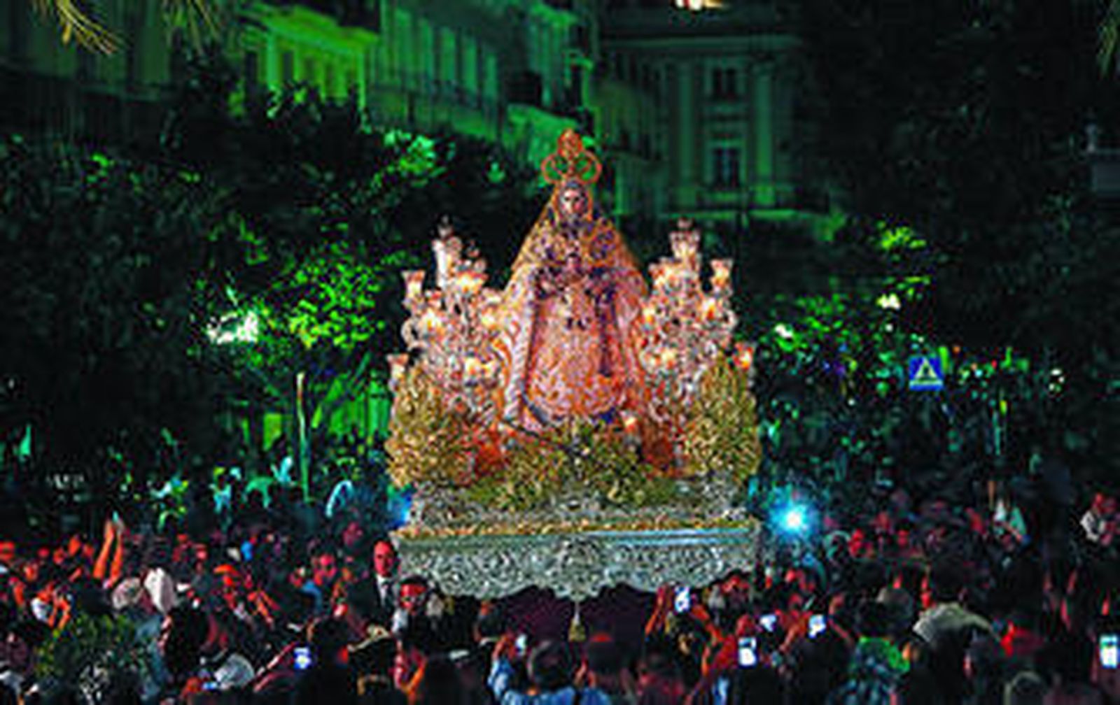 Novedosa estampa del paso de la Patrona por Canalejas, ya vencida la noche y con numeroso público alrededor de la Virgen.