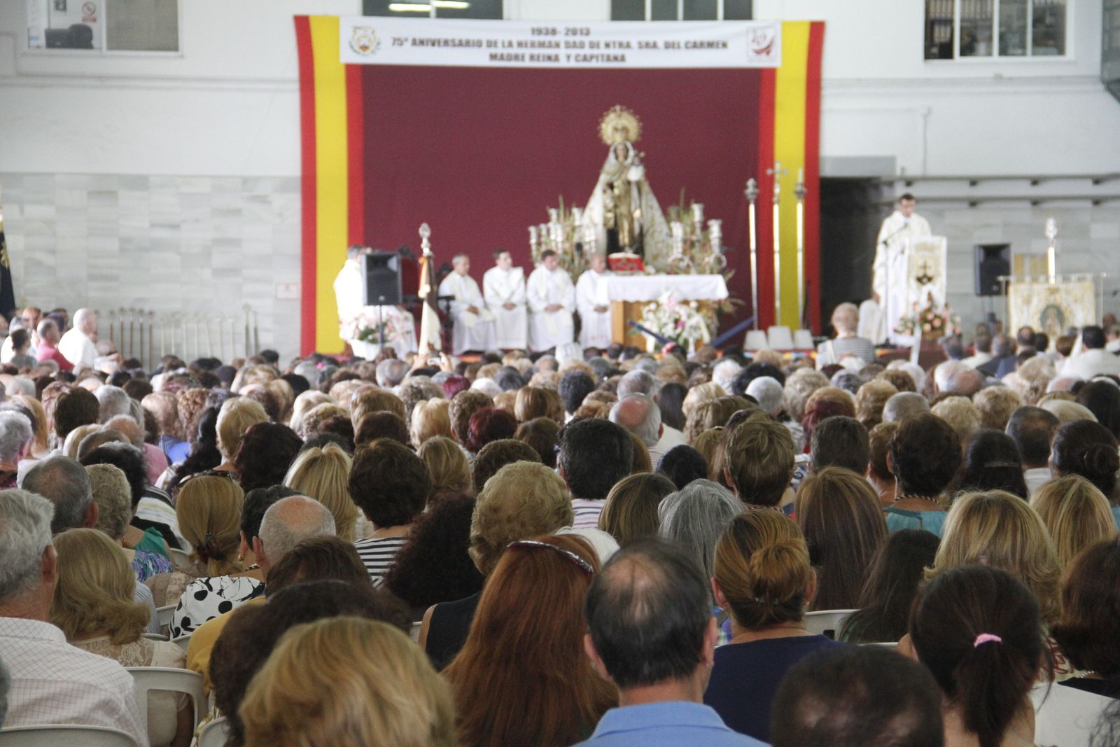 Cientos de devotos de la Virgen  del Carmen  durante la eucaristía que se oficia en la lonja pesquera.