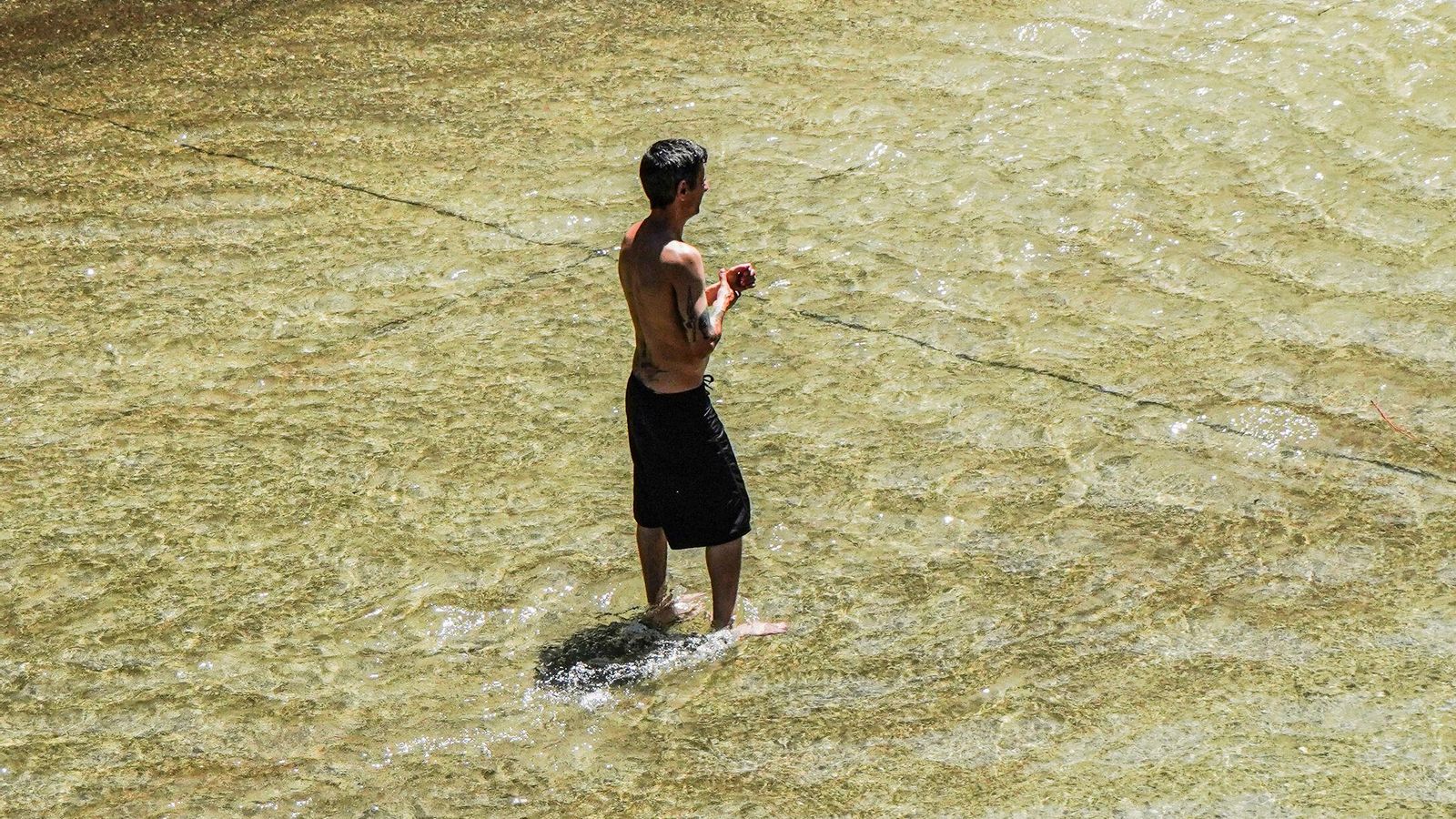 Un hombre se refresca en Granada Un hombre se refresca en Granada