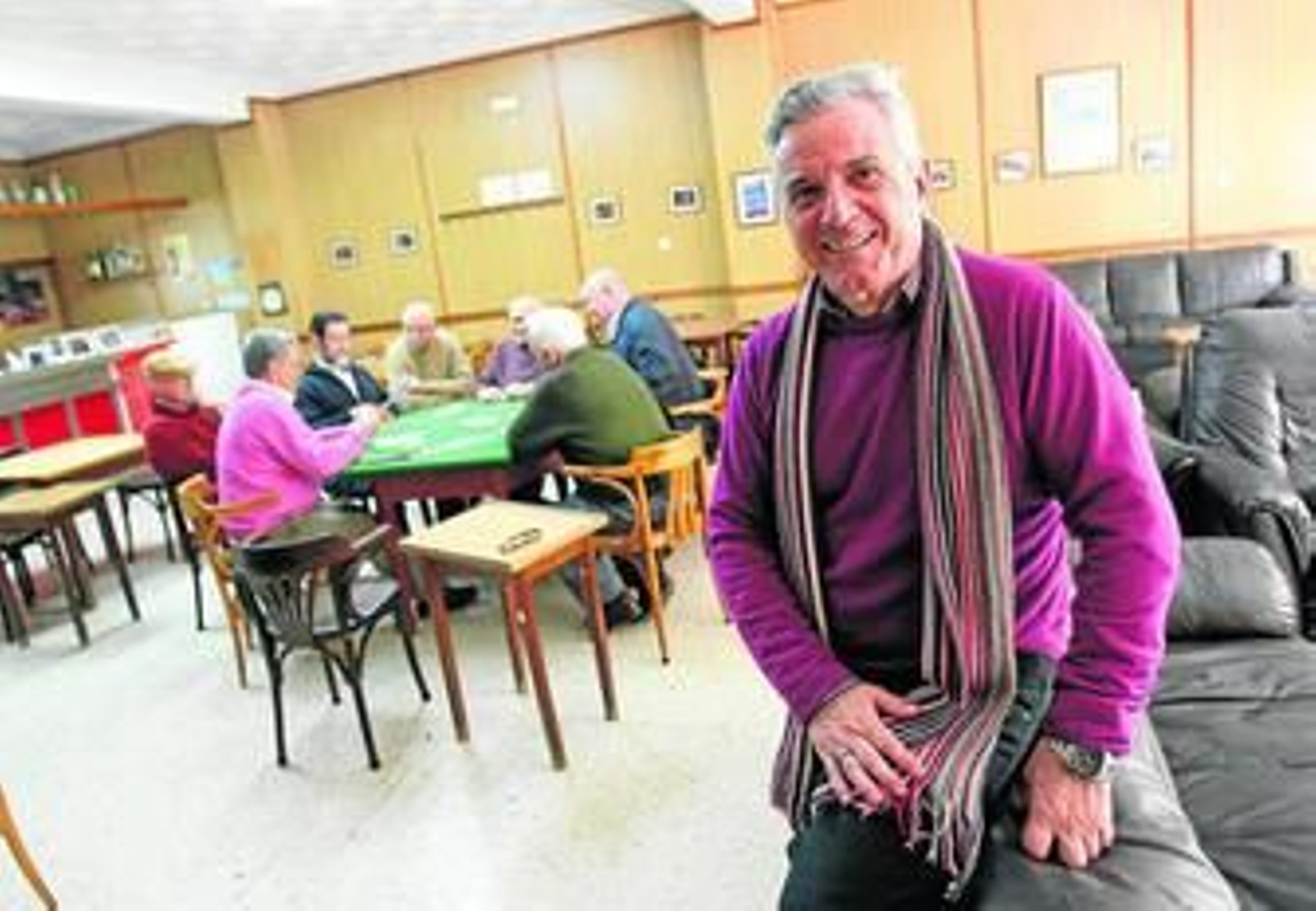 El presidente del Círculo Mercantil de La Línea, Manuel Moreno, posa en la cafetería de la entidad. Al fondo, varias personas juegan a las cartas.